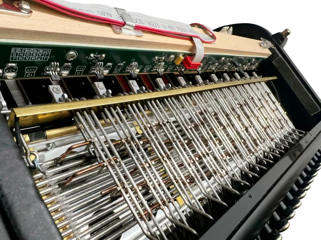 Système MIDI Essentiel Cavagnolo intégré dans la main gauche d'un accordéon.